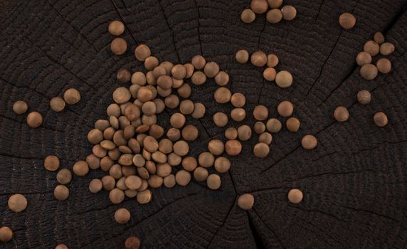 Lentils grain on black wooden background, top view