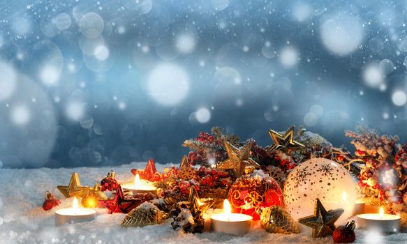 Christmas composition of colorful ornaments balls stars candles and fir tree branches on snow
