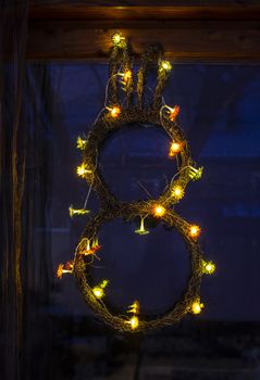 Bunny easter decoration on wall. Flowers lights on bunny shape. 