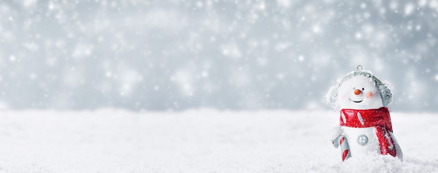 Christmas Snowman toy on winter background in the snow