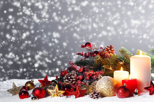 Christmas composition of colorful ornaments balls stars candles and fir tree branches on snow