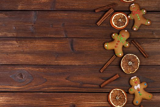 Christmas flat lay background with traditional gingerbread cookies dried orange cinnamon on wood