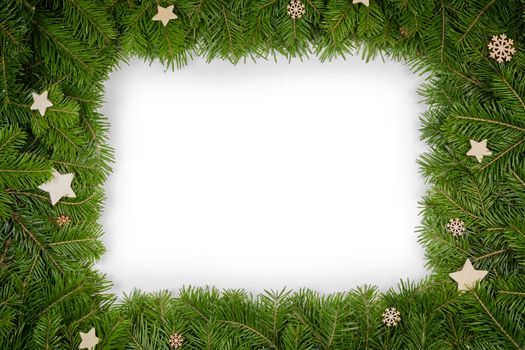 Christmas border arranged with fresh fir branches and wooden decor isolated on white background , copy space for text