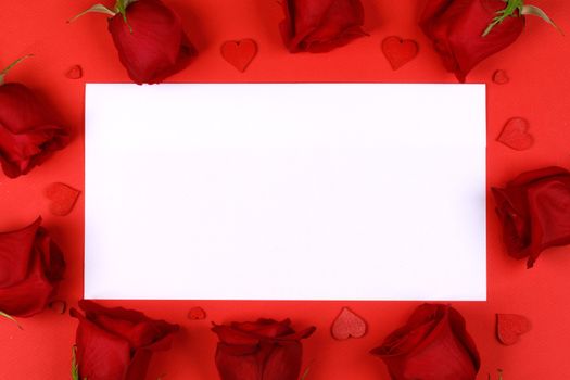 Red roses and red hearts composition and white card background top view with copy space. Valentine's day, birthday, wedding, Mother's day concept. Copy space