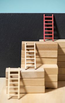 Ladders on the wall. Concept for success and growth. Stairs made of wooden blocks. Blue wall. 