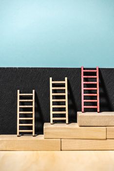 Ladders on the wall. Concept for success and growth. Stairs made of wooden blocks. Blue wall. 