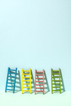 Multicoloured ladders on wall. Pastel tones. Concept for success and growth. Business metaphors.