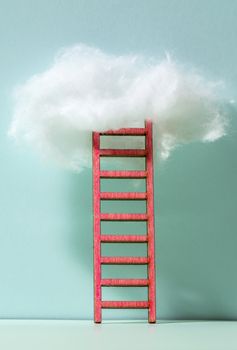 Red ladder to the clouds metaphor. Concept for growth and internet cloud networking. Blue wall.