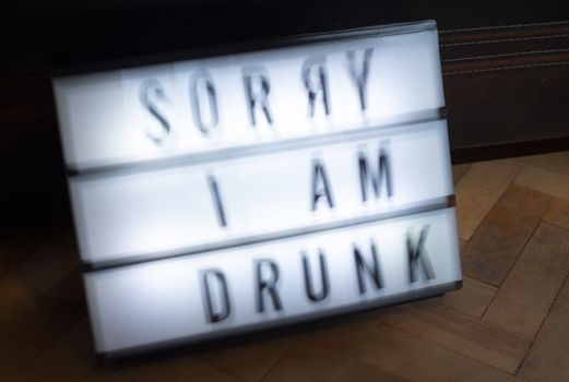 Text - Sorry I am drunk on white illuminated board. Concept for alcohol and drinking. Blurred text.