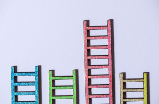 Multicoloured ladders on wall. Pastel tones. Concept for success and growth. Business metaphors.