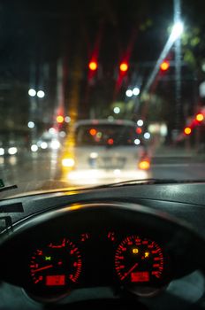 Car dashboard and window at night. Traffic lights