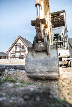 Excavator and newly built houses on construction site