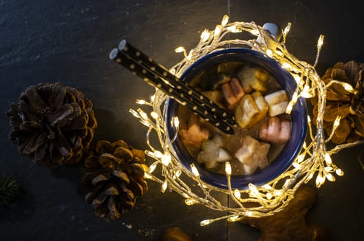 Cup of milk and Marshmallow. Christmas lights and ornaments