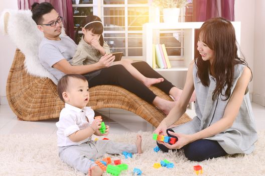 Asian family playing toys at living room