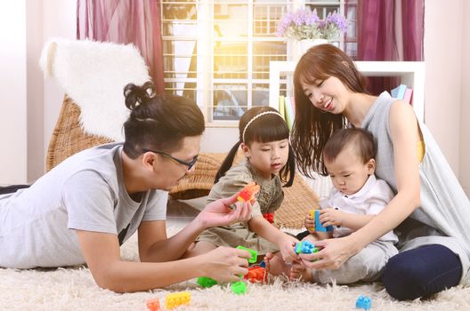 Asian family playing toys at living room