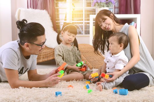 Asian family playing toys at living room