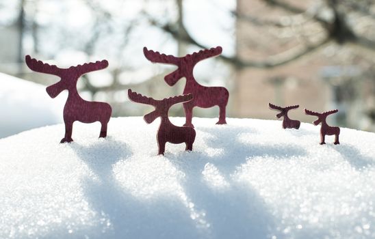 Wooden Christmas deer shape on snow.