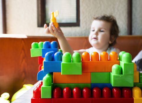 Child playing with cubes. Puts a cube
