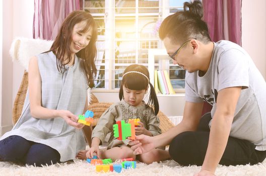 Asian family playing toys at living room