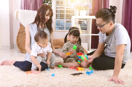 Asian family playing toys at living room