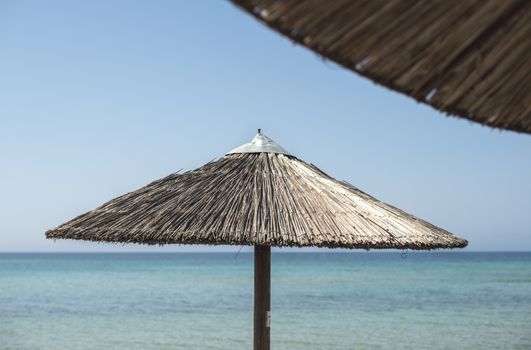 Straw umbrella on the beach. Blue sky. Sunny day