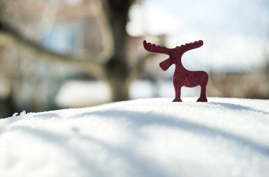 Wooden Christmas deer shape on snow.