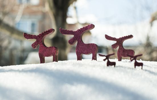 Wooden Christmas deer shape on snow.