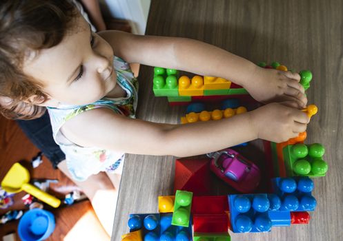 Little girl playing with multicolor blocks