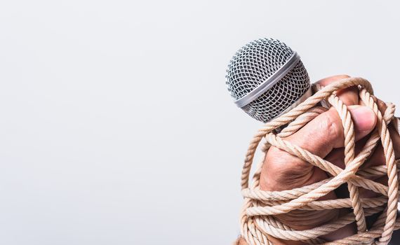 Hand holding microphone and have roped on fist hand on white background, Human rights day concept