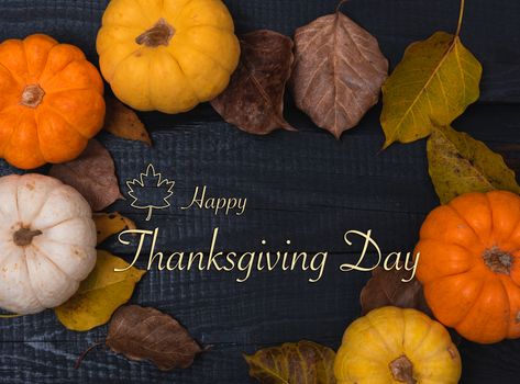 Fall Thanksgiving and Halloween pumpkins and dry leaves on wooden background, top view shot