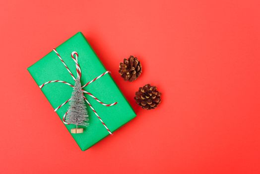 New Year, Christmas Xmas holiday composition, Top view green gift box and green fir tree branch on red background