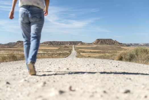 Woman walking on dirt road. Looking like a movie