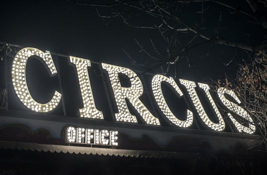 Text circus in the night. Circus office illuminated. Many lamps