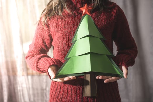 Woman in red sweater hold fir christmas tree.