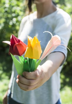 Woman hold bouquet of origami flowers. Origamy tulips