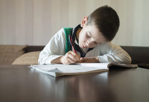 Child do his homework. Notebook for mathematic. Hand hold pen. Boy learning