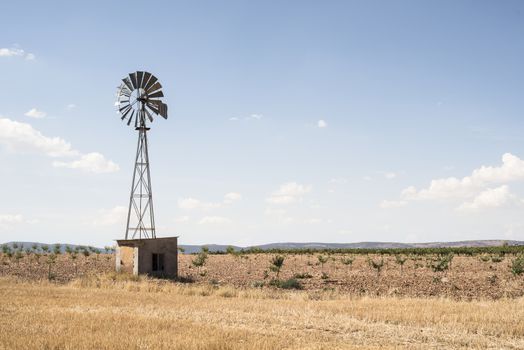 Old windmill at blue cloudy sky