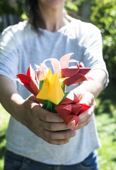 Woman hold bouquet of origami flowers. Origamy tulips