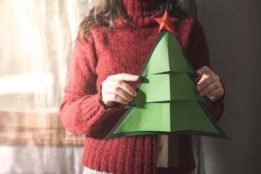 Woman in red sweater hold fir christmas tree.