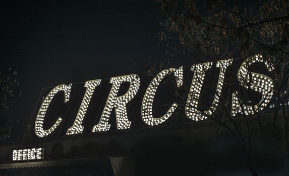 Text circus in the night. Circus office illuminated. Many lamps