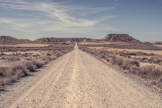 Woman walking on dirt road. Looking like a movie