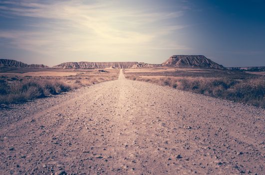 Woman walking on dirt road. Looking like a movie