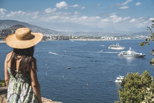 Woman with summer hat watching yachts. French riviera