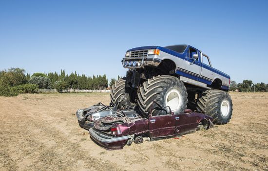 Monster truck over cars. Blue sky