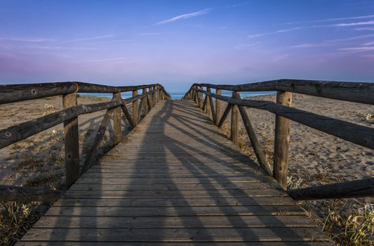 Wooden path to the beach. Morning sky