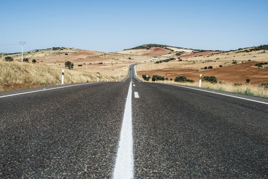 Long asphalt road and blue sky.