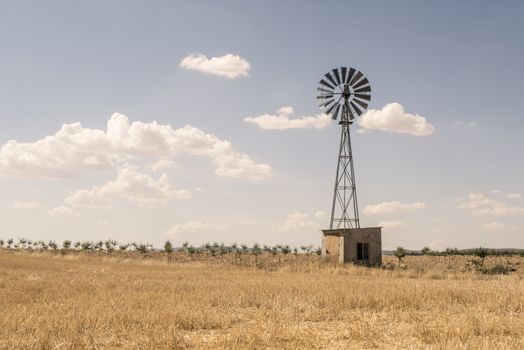 Old windmill at blue cloudy sky