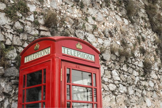 Red telephone cabin and stone wall