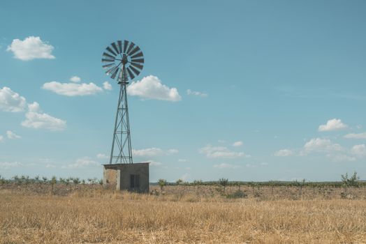 Old windmill at blue cloudy sky