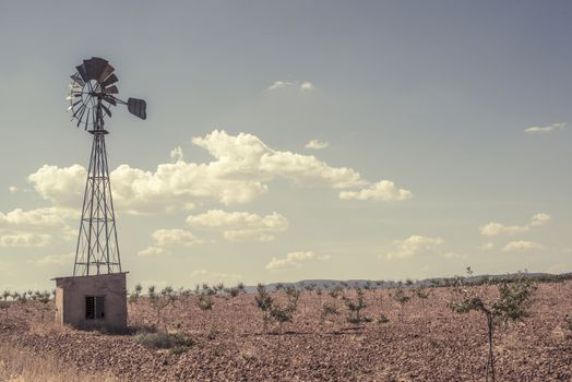 Old windmill at blue cloudy sky